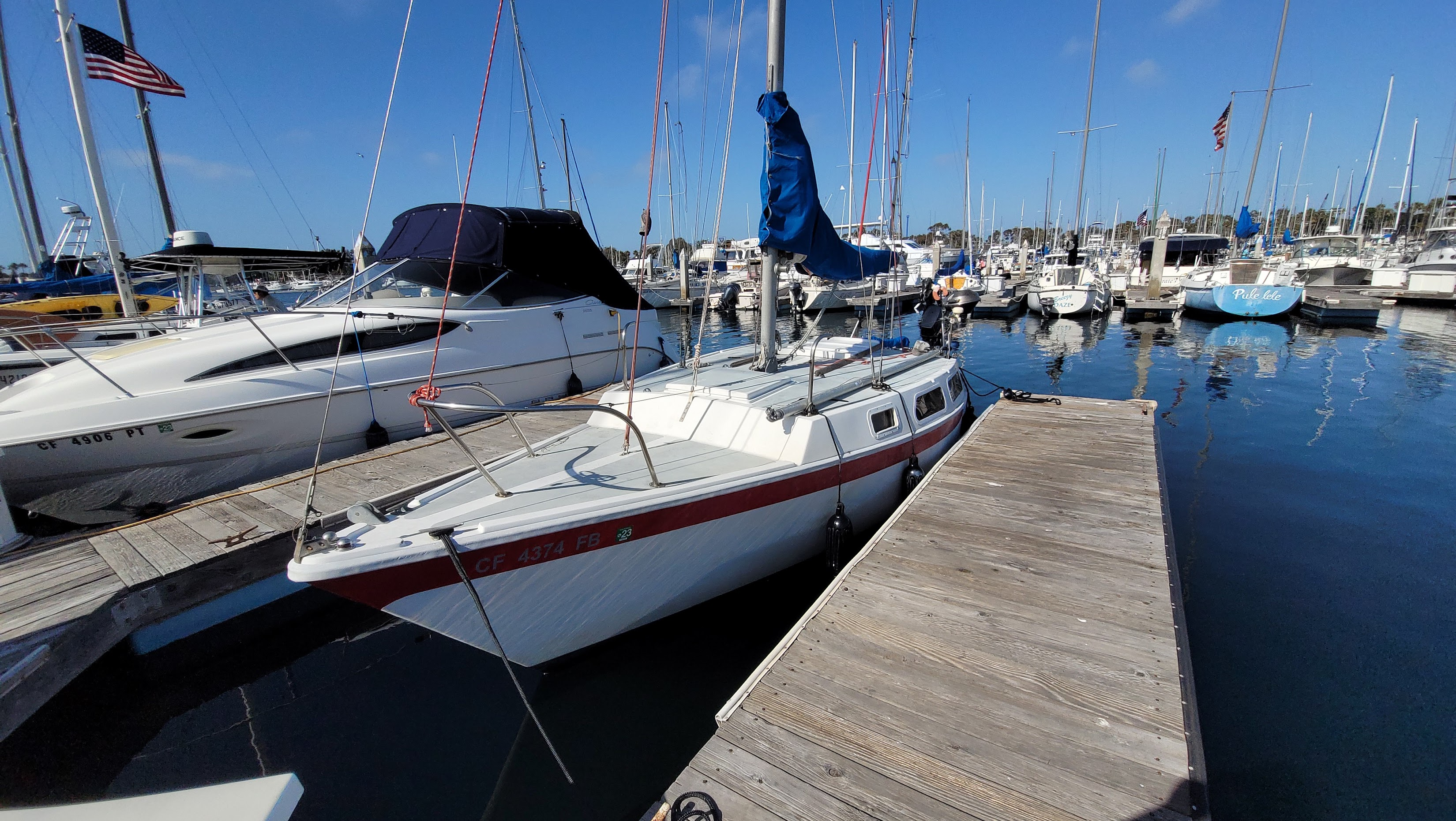The white and red Cal T/4 sailboat at her marina slip